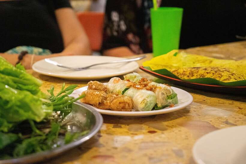 Phnom Penh: Evening Food Tour with Drinks & Tuk Tuk Included - Russian Market after dark, with grilled food and sweets
