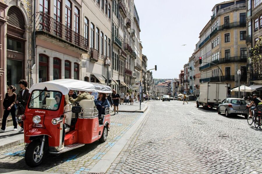 Porto: Guided Tour by Tuk-Tuk & Optional Douro River Cruise - Clerigos Tower and Lello Bookshop from the road