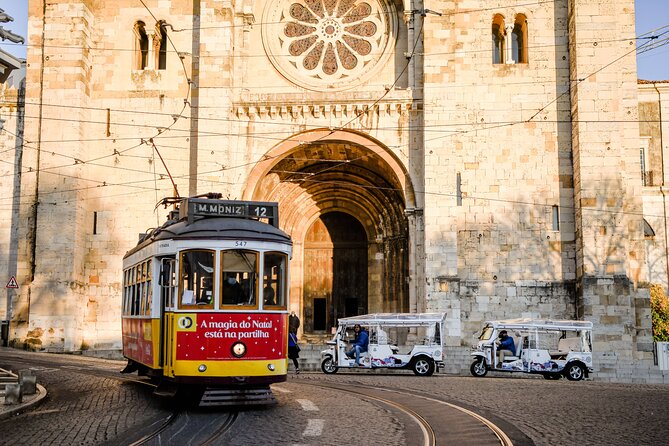 A tuk tuk waiting beside the tram tracks below Lisbon cathedral